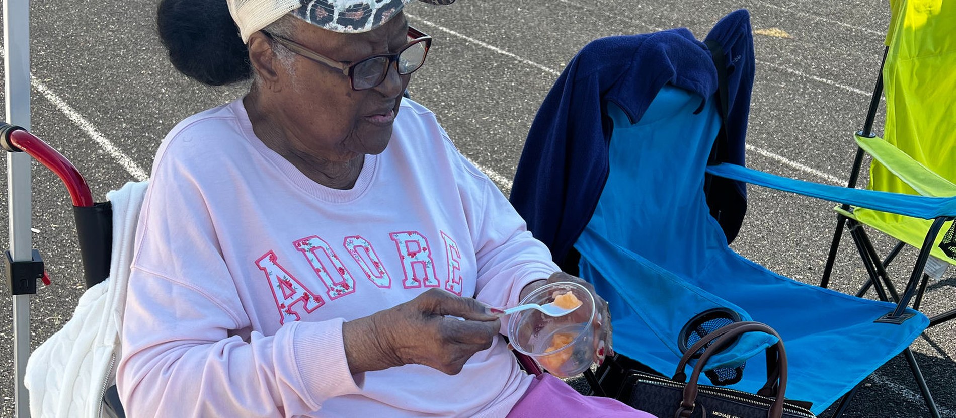 A smiling community member enjoying a cup of IcyScott Italian ice