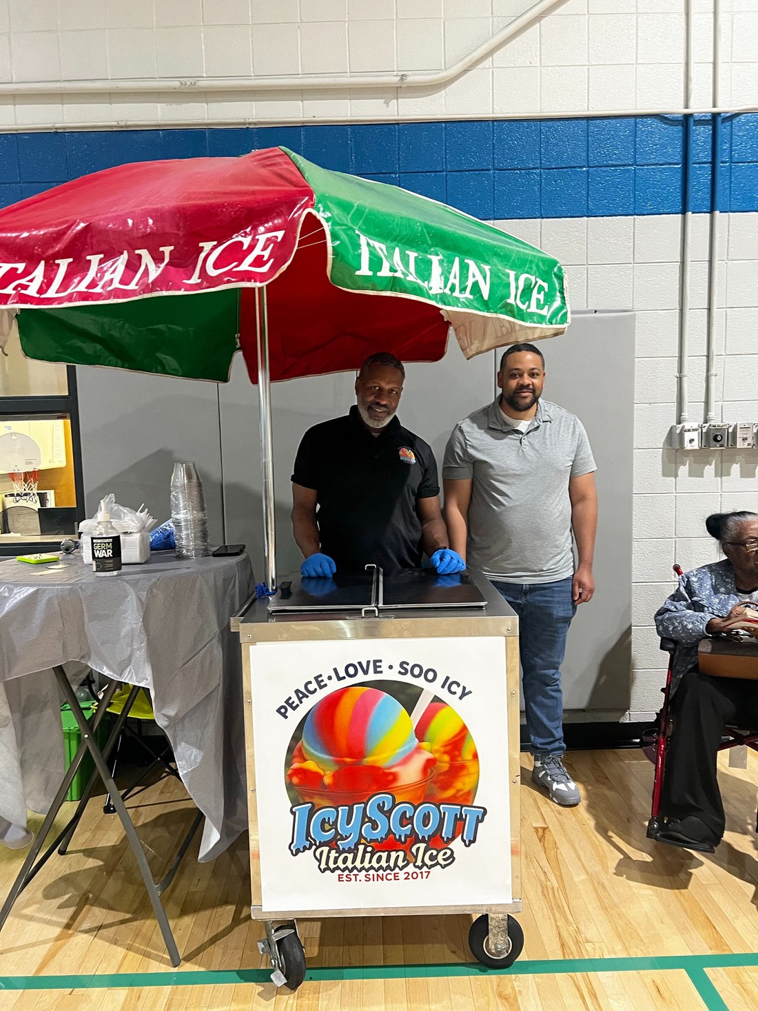 The IcyScott family team behind their Italian ice cart under the striped umbrella